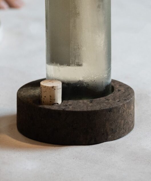 garrafa numa base de cortiça de aglomerado negro puro